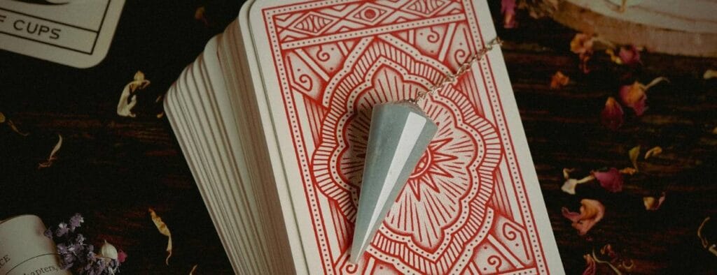 pendule divinatoire posé sur un paquet de carte