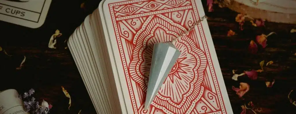 pendule divinatoire posé sur un paquet de carte