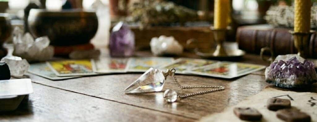 pendule posé sur une table avec décoration ésotérique autour