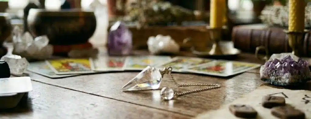 pendule posé sur une table avec décoration ésotérique autour