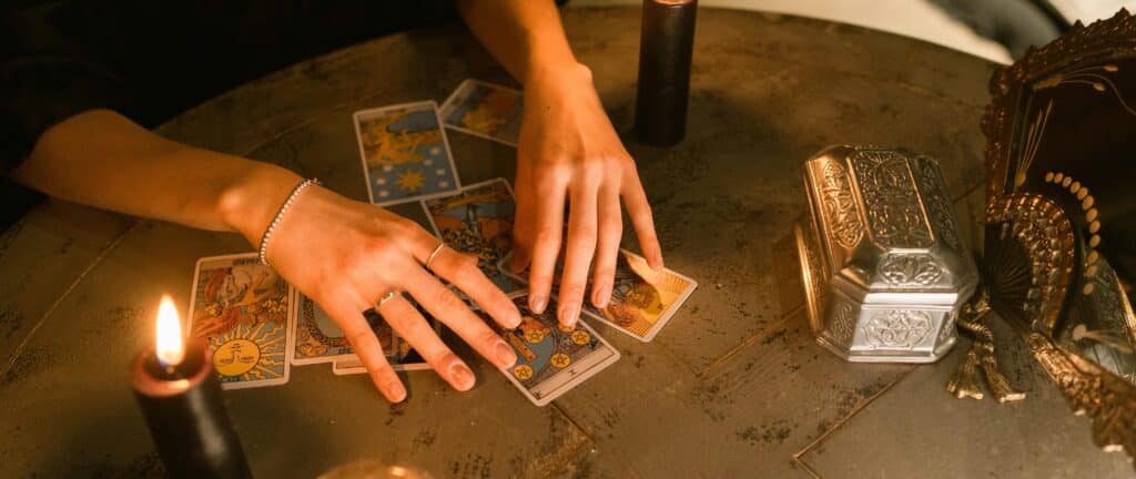 Voyante qui tire les cartes avec des bougies autour et une boule de cristal