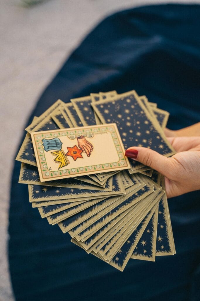 Femme qui tient un paquet de carte de tarot de marseille en éventail